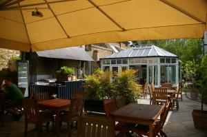 a patio with tables and chairs and a greenhouse at The Victoria in London