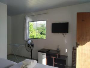 Habitación con ventana y ventilador. en Nova Beco das Cores Flats e Pousada, en Serra do Cipo