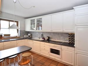 a kitchen with white cabinets and a black counter top at Cottage in Rinchnach Bavaria near the forest in Rinchnach