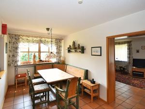 Cottage in Rinchnach Bavaria near the forest في Rinchnach: مطبخ وغرفة طعام مع طاولة وكراسي