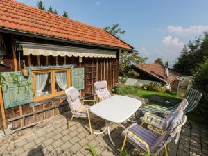 a patio with a table and chairs in front of a house at Idyllic holiday home with terrace in Hohenpeißenberg