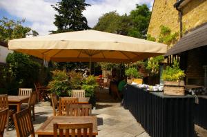 un patio con mesas y una sombrilla grande en The Victoria en Londres