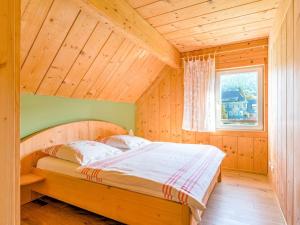 a bed in a wooden room with a window at Apartment with barbecue in M hrenbach in Möhrenbach