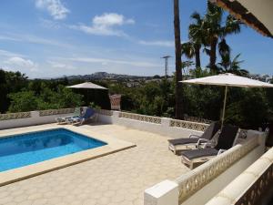 モライラにあるSpanish Villa in Moraira with Private Poolのスイミングプール(椅子2脚、パラソル付)