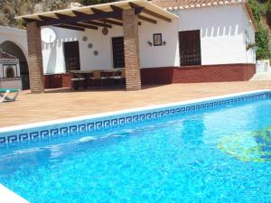 a swimming pool in front of a house at Belvilla by OYO Casa Mirador in Nerja