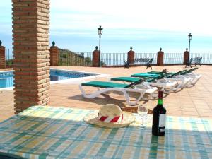 Una mesa con una botella de vino y un sombrero. en Belvilla by OYO Casa Mirador, en Nerja