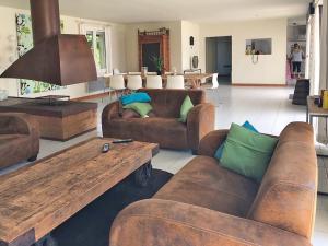 salon z brązowymi kanapami i drewnianym stołem w obiekcie Modern villa with private pool w mieście Brives-sur-Charente