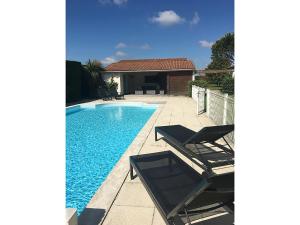 basen z dwoma krzesłami i dom w obiekcie Modern villa with private pool w mieście Brives-sur-Charente