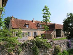 a house on a hill with a stone wall at Beautiful farmhouse in Braize with private garden in Coust