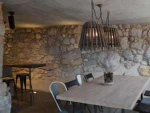 OdenにあるBelvilla by OYO Cobert de l Eraの石壁のダイニングルーム(テーブル付)