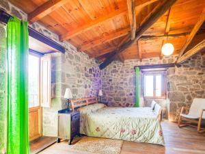 a bedroom with a bed and a stone wall at Holiday Home in Castrotañe near Sil Cañon in Castillón