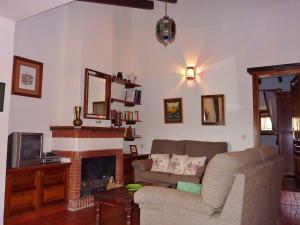 a living room with a couch and a fireplace at Belvilla by OYO El Trigal in Villanueva de la Concepción
