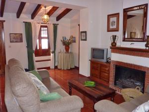a living room with a couch and a fireplace at Belvilla by OYO El Trigal in Villanueva de la Concepción