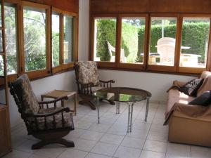 ベグールにあるBelvilla by OYO La Pinedaのリビングルーム(椅子、テーブル、窓付)