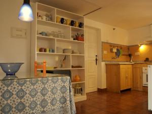 una cocina con estanterías blancas y una mesa en una habitación en Belvilla by OYO Casa Candela, en Ronda