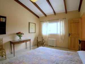 a bedroom with a bed and a desk and a window at Belvilla by OYO Casa Candela in Ronda