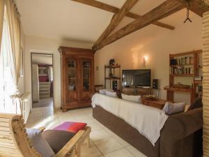 sala de estar con sofá y TV en Villa in Saint Nexans with Private Heated Pool, en Saint-Nexans