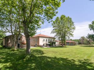 une ancienne maison dans un champ arboré dans l'établissement Beautiful Villa with Swimming Pool in Artigat, à Artigat