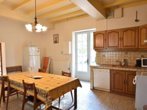 a kitchen with a table with chairs and a refrigerator at Cosy holiday home with pool in Lamonzie-Montastruc