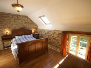 ein Schlafzimmer mit einem Bett und einer Steinmauer in der Unterkunft Holiday Home in Saizy with Patio in Vignol