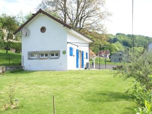 Casa blanca con puertas azules y patio en Cosy holiday home with garden en Fresse-sur-Moselle