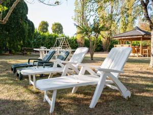 una fila de sillas blancas en un parque en Superb villa with private garden in V lines, en Vélines