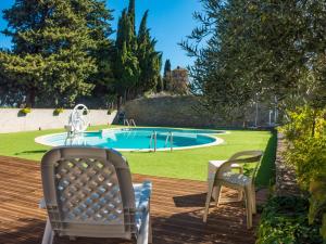 una terraza con 2 sillas y una piscina en Stone cottage on an active wine growing estate, en Conilhac-Corbières
