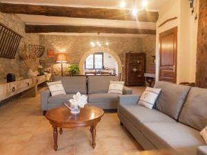 a living room with two couches and a table at Stone cottage on an active wine growing estate with a swimming pool in Conilhac-Corbières