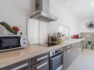 a kitchen with a microwave oven and a sink at Luxury holiday home with lawn in Beaumont-en-Véron