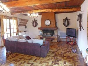 a living room with a couch and a clock on the wall at Holiday home with swimming pool in Félines-Minervois