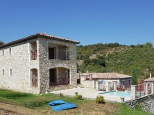 una casa de piedra con piscina frente a ella en Cosy holiday home with views and private pool, en Saint-Ambroix