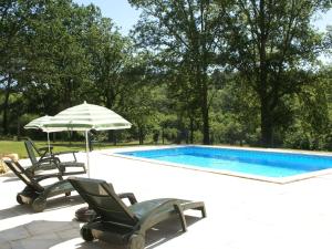 Saint-Cernin-de-lʼHermにあるPicturesque holiday home with poolのスイミングプール(椅子2脚、パラソル付)