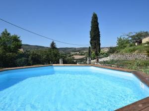 een groot blauw zwembad met een heuvel op de achtergrond bij Peaceful holiday home with pool in Saint-Pons