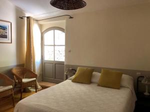 Un dormitorio con una cama con almohadas amarillas y una ventana en Stylish house with heated pool in Lacoste, en Lacoste