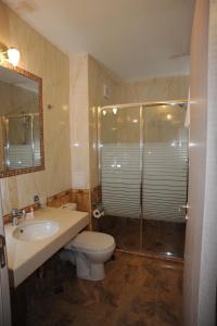 y baño con aseo, lavabo y ducha. en Hotel Adria, en Sofía