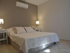 Superb holiday flat with private pool في كاربينترا: غرفة نوم بسرير مع طاولتين ومصباحين