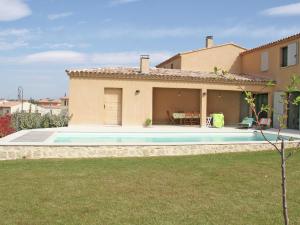 a villa with a swimming pool in front of a house at Luxury villa with private swimming pool in Malaucène