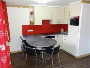 une petite cuisine avec une table et des chaises dans l'établissement Simplistic Apartment in M ribel near Les 3 Vall es, à Méribel