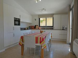 una cocina con una mesa con un colorido mantel. en Luxury villa with private swimming pool, en Malaucène