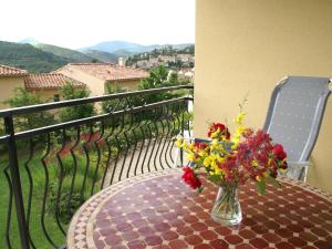 un vase de fleurs posé sur une table sur un balcon dans l'établissement Cycling Escape in Montbrun, à Montbrun-les-Bains