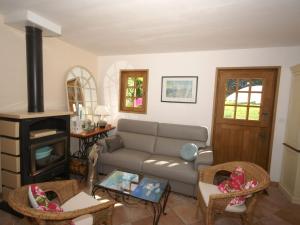 a living room with a couch and a stove at Traditional house with garden in Dampsmesnil in Écos