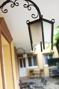 une lampe suspendue à un bâtiment avec une table et des chaises dans l'établissement Apartments & Rooms Vienna, à Osijek