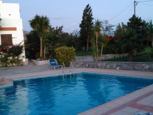 LefkogeiaにあるChic Villa in Lefkogia Crete with Swimming Poolのスイミングプール(椅子付)と家