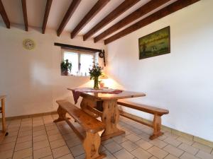 a dining room with a wooden table and benches at Lovely holiday home with garden terrace and fantastic view in Guilberville in Fourneaux