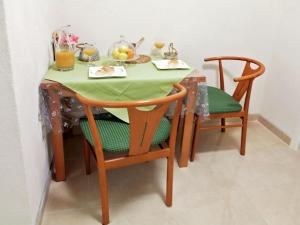 a table with a green table cloth and two chairs at Charming little apartment with a balcony and a sea view 5 minutes to the beach in Brela