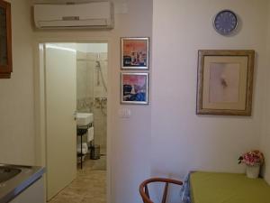 a bathroom with a clock on the wall and a table at Charming little apartment with a balcony and a sea view 5 minutes to the beach in Brela