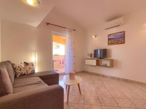 uma sala de estar com um sofá e uma mesa em Spacious Holiday Home in Peroj with Private Pool em Peroj