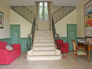 a staircase in a living room with red furniture at Superb country house with private pool in Vaison-la-Romaine