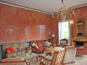 a living room with a red wall at Superb country house with private pool in Vaison-la-Romaine