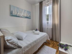 a white bedroom with a bed and a window at Villa in Razanac with Pool near Pebble Beach in Ražanac +30 photos